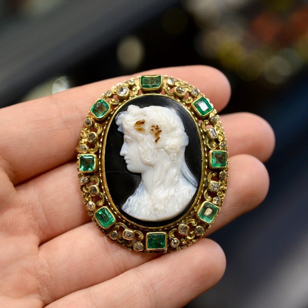 A Flora Cameo Emerald Diamond And Yellow Gold Brooch-Pendant, circa 1870’s 

Brooch/Pendant decorated with a cameo representing Flora in profile on agate in a surround of emeralds and old-cut diamonds. Obverse mount with chiseled decoration in 18K yellow gold. Dimensions: 5.7 x 4.1 cm. Gross weight: 24.61 gr.